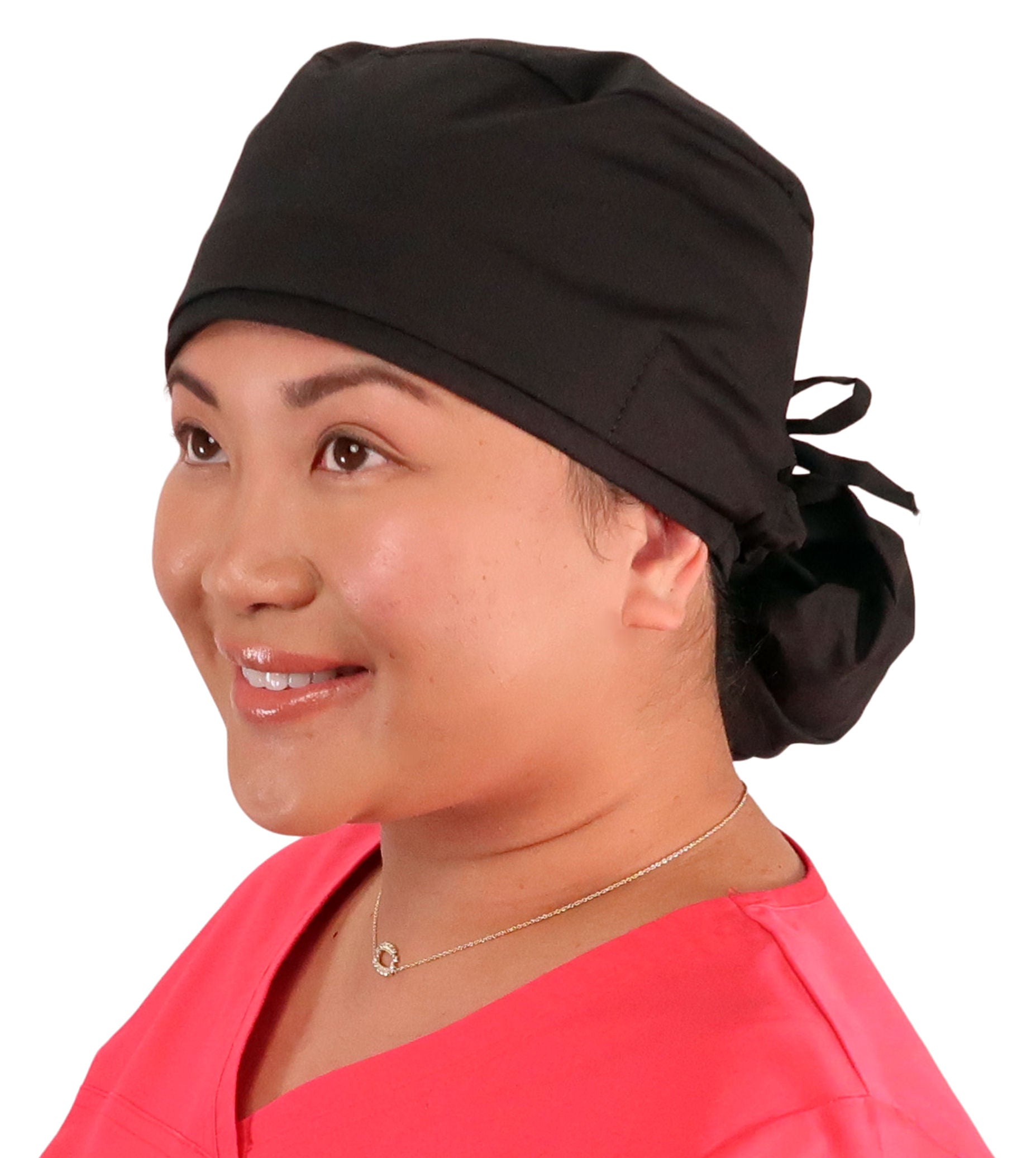 Front facing image of a woman in scrubs wearing a Black Big Hair Ponytail Scrub Cap with Black ties to hold the scrub cap in place.