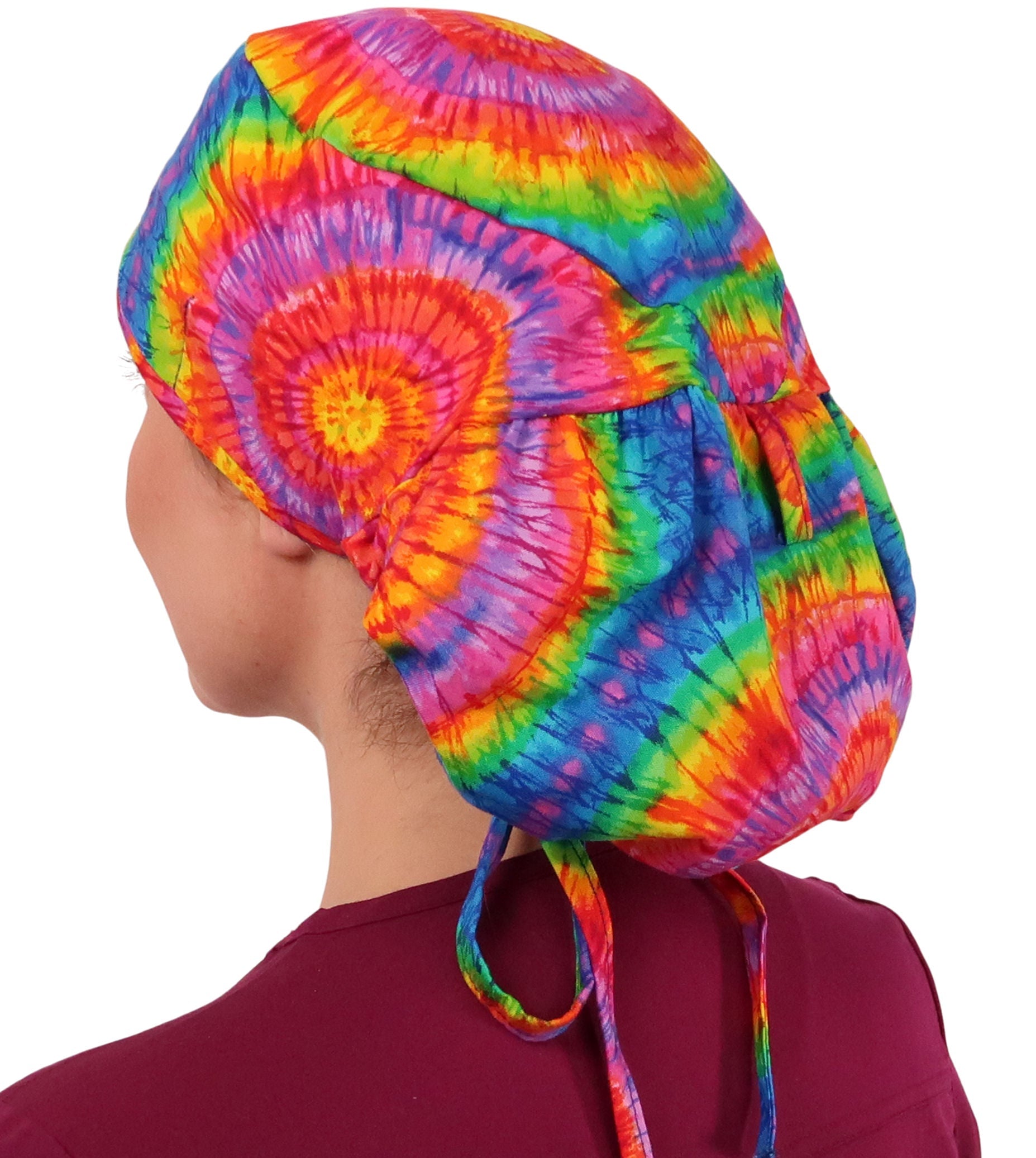 Side facing image untied of a woman in scrubs wearing a Big Hair Ponytail Scrub Cap with a Tie Dye pattern.