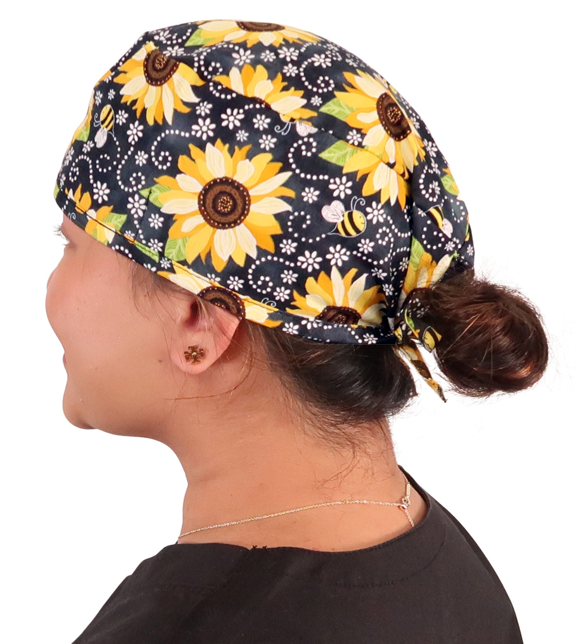 Side facing image of a woman in scrubs wearing a Classic Surgical Scrub Cap in a  Sunflowers on Black pattern.