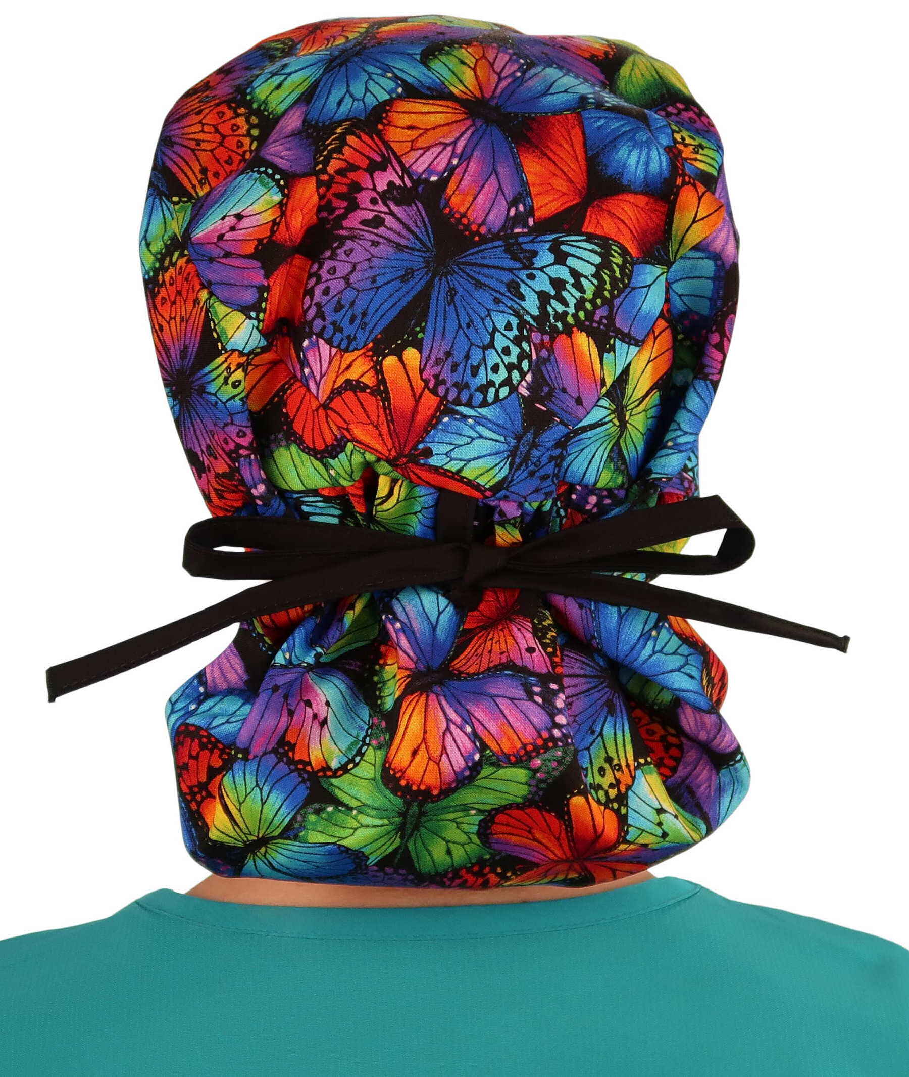 Back facing tied image of a woman in scrubs wearing a Big Hair Ponytail Scrub Cap with a Butterfly Me Away pattern, and black ties to hold the scrub cap in place.