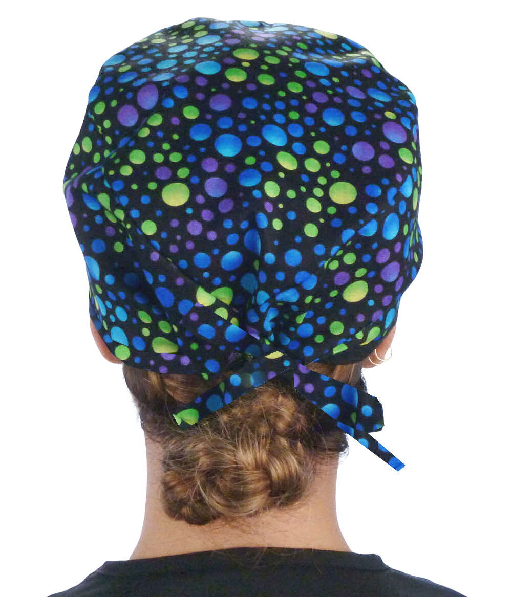 Back facing image of a woman in scrubs wearing a Classic Surgical Scrub Cap in a Blue, Green and Purple Dots pattern.