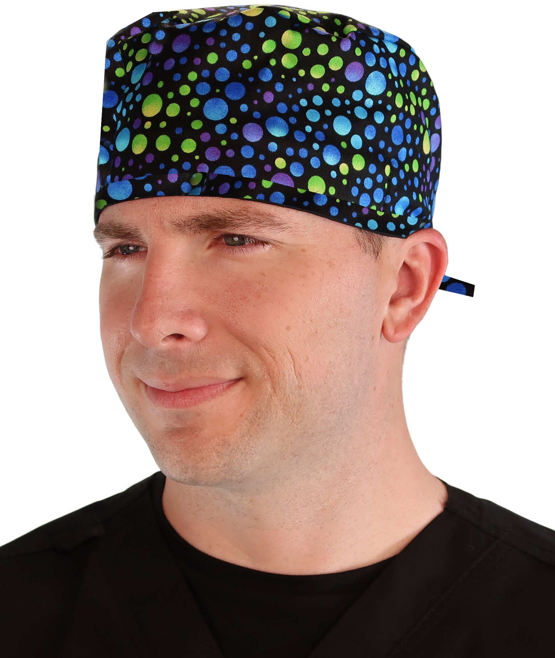 Front facing image of a man in scrubs wearing a Classic Surgical Scrub Cap in a Blue, Green and Purple Dots pattern.