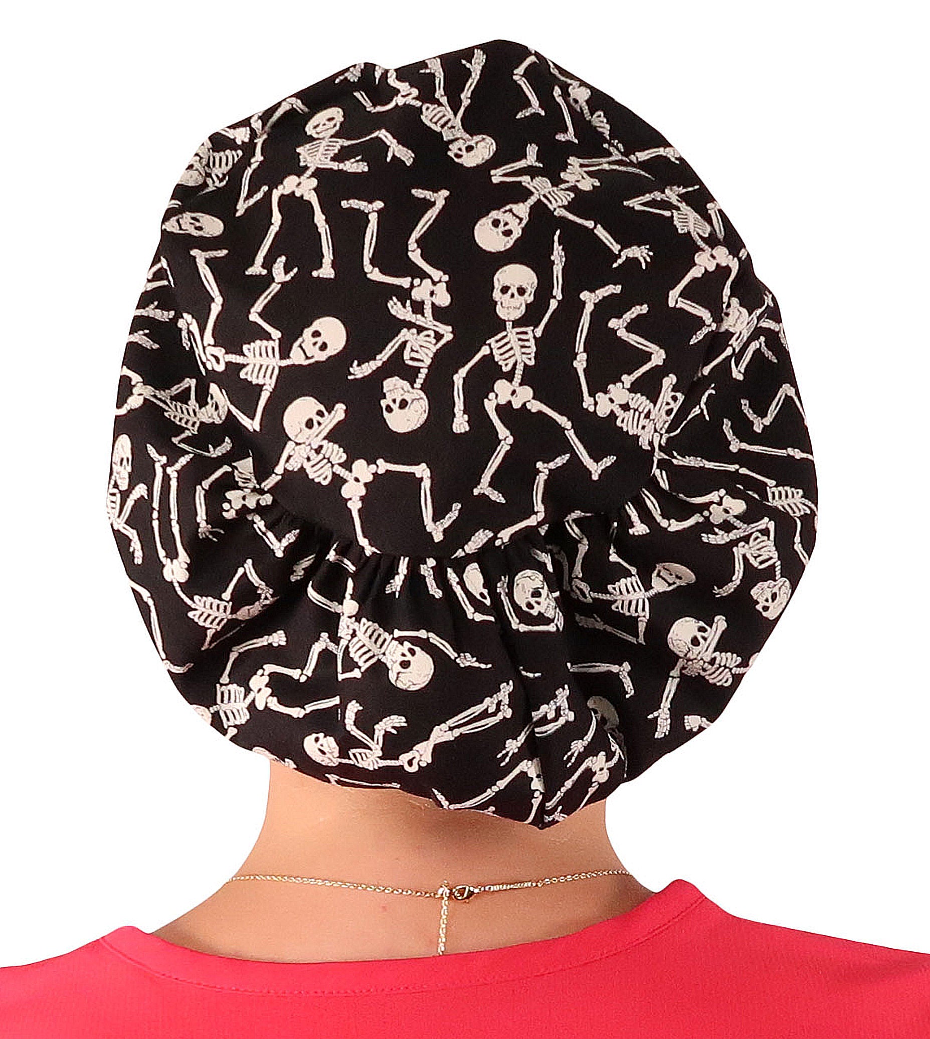 Back facing image of a woman in scrubs wearing a Dancing Skeletons (Glow In The Dark) Euro Style Riley Comfort Scrub Cap.