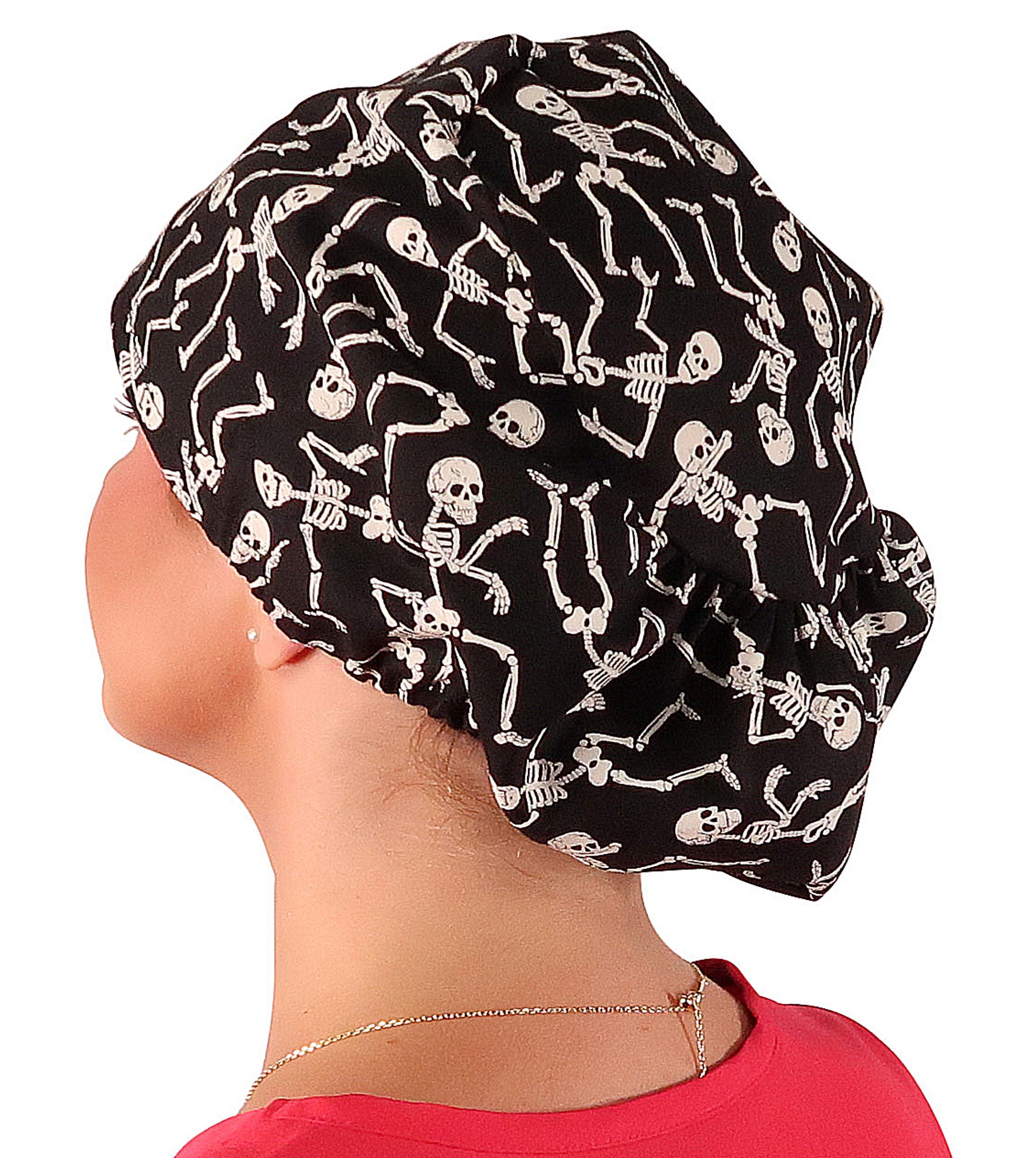 Side facing image of a woman in scrubs wearing a Dancing Skeletons (Glow In The Dark) Euro Style Riley Comfort Scrub Cap.