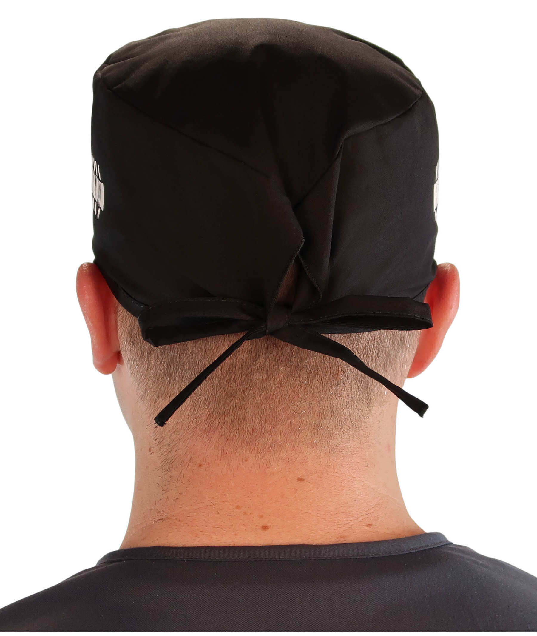 Back facing image of a man in scrubs wearing a Classic Surgical Scrub Cap in a Bones on Black pattern.