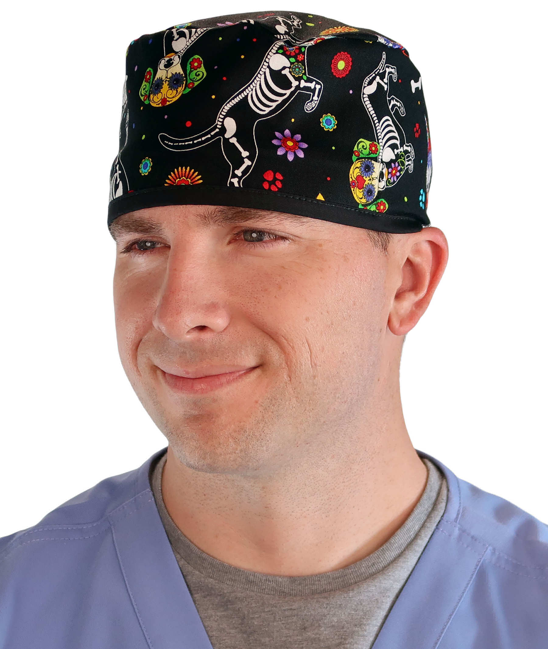 Front facing image of a man in scrubs wearing a Classic Surgical Scrub Cap in a X Ray Dogs with black ties pattern.