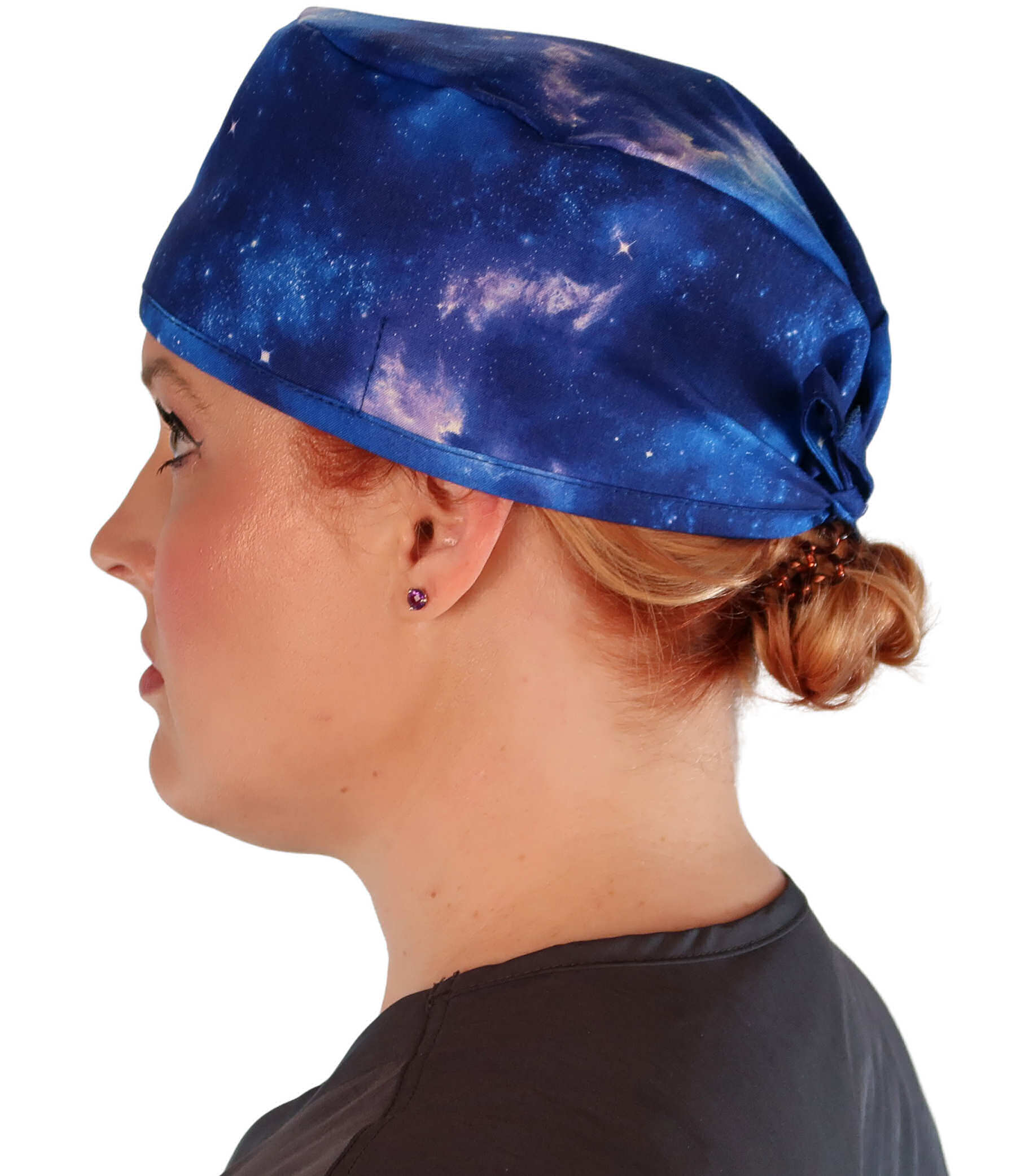 Side facing image of a woman in scrubs wearing a Classic Surgical Scrub Cap with a Starry Sky pattern.