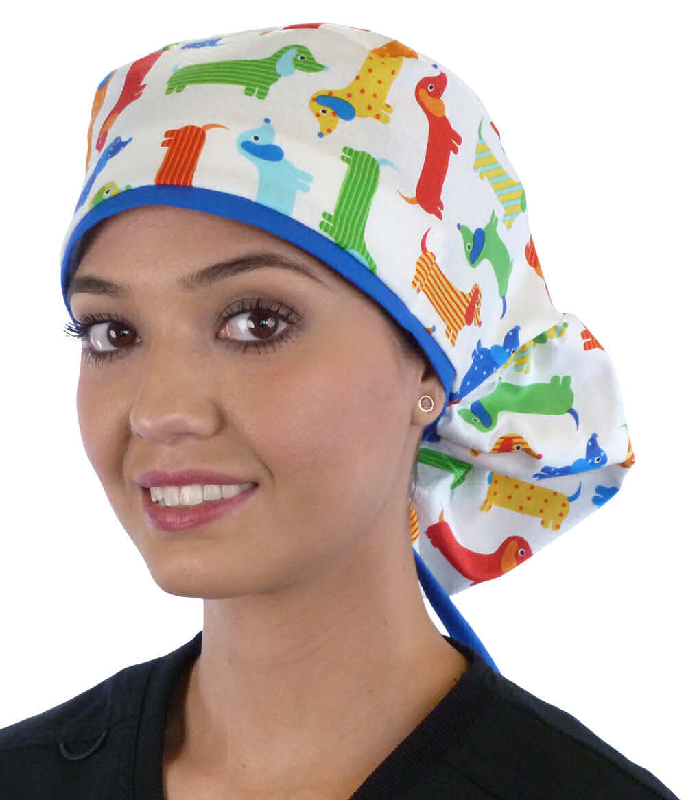 Front facing untied image of a woman in scrubs wearing a Big Hair Ponytail Scrub Cap with a Tossed Wiener Dogs pattern, and royal ties to hold the scrub cap in place.