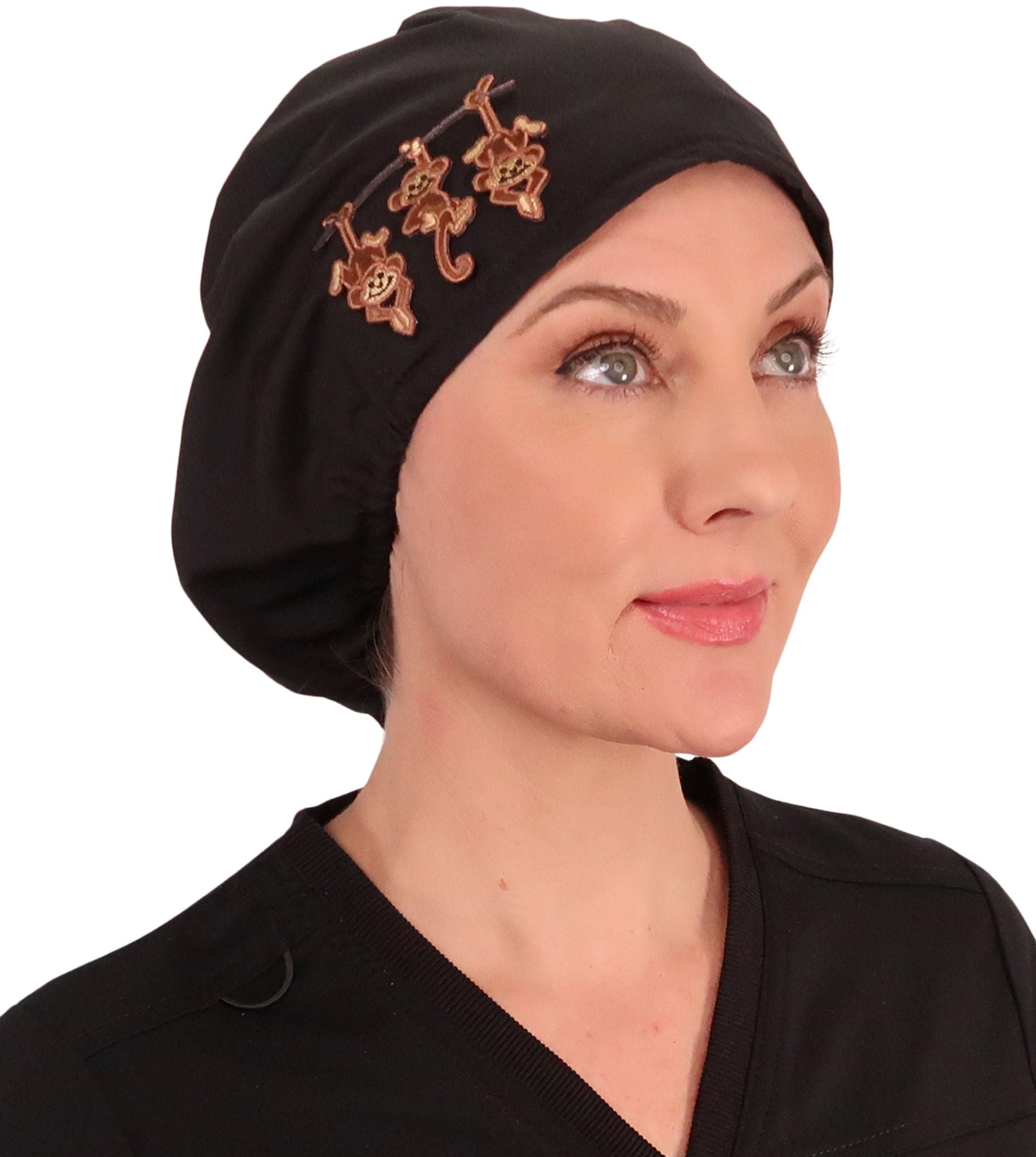 Side facing image of a woman in scrubs wearing a Three Monkeys Patch on Black Euro Style Riley Comfort Scrub Cap.