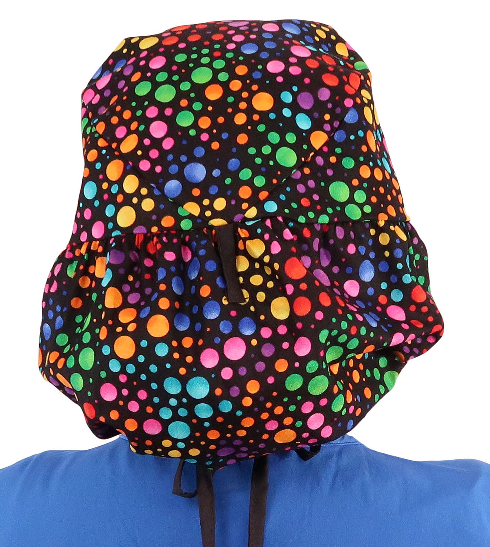 Back facing untied image of a woman in scrubs wearing a Big Hair Ponytail Scrub Cap with a Multi Color Dots pattern, and black ties to hold the scrub cap in place.