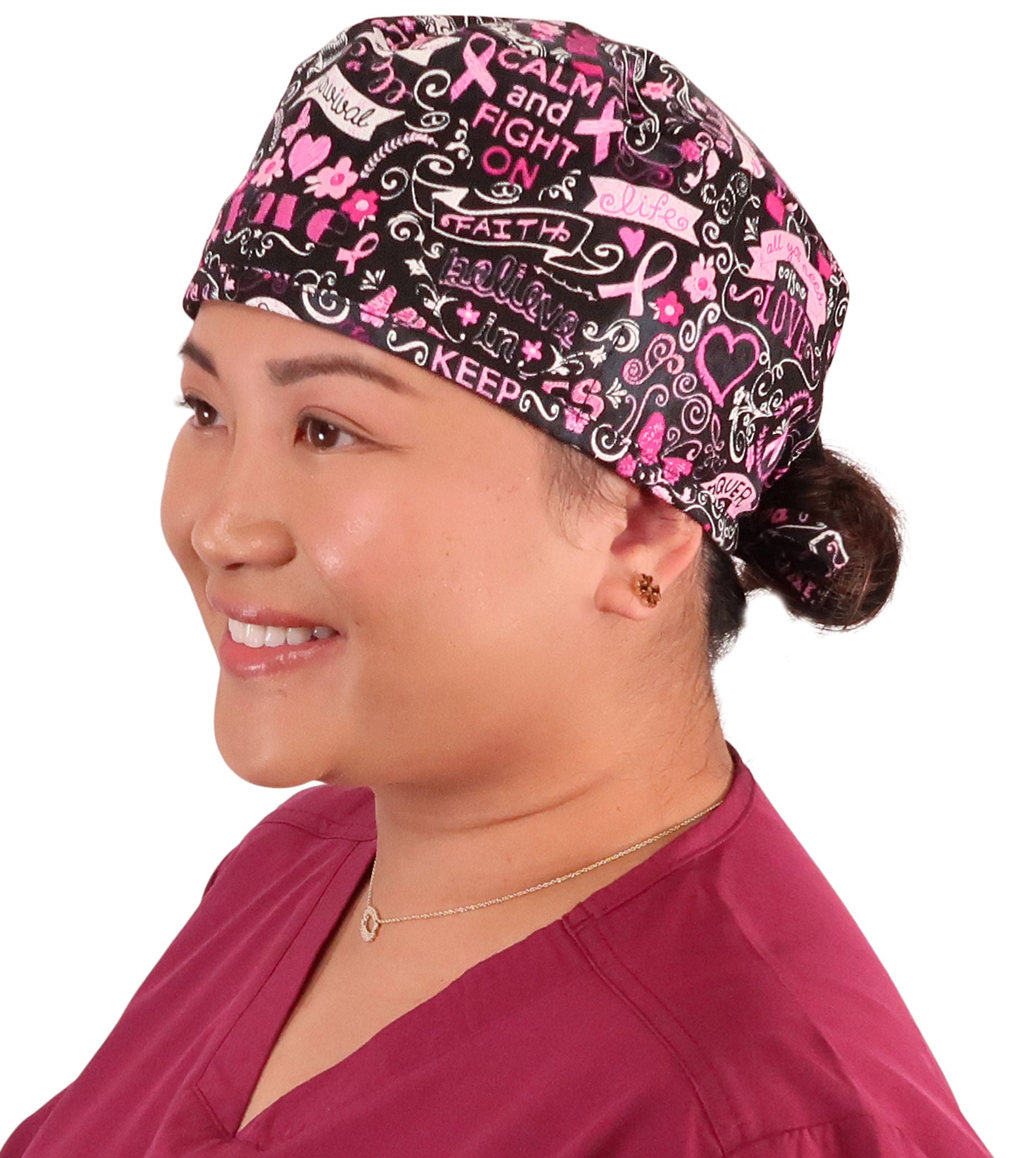 Front facing image of a woman in scrubs wearing a Classic Surgical Scrub Cap in a Pink Ribbon Collage on Black pattern.