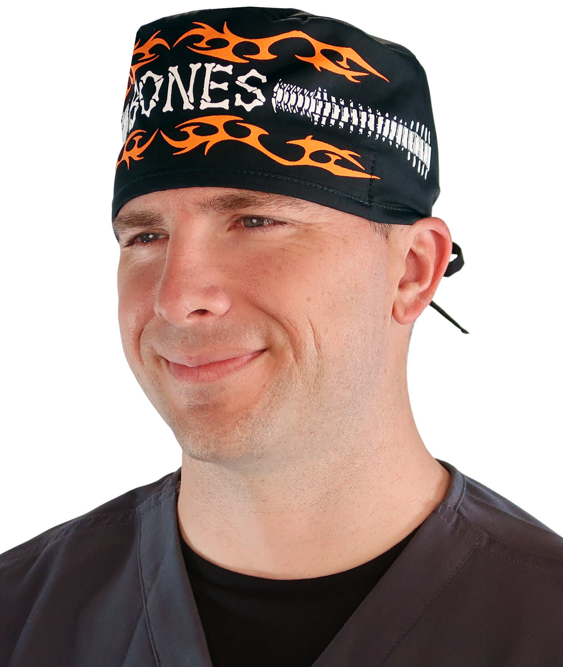 Front facing image of a man in scrubs wearing a Classic Surgical Scrub Cap in a Bones on Black pattern.