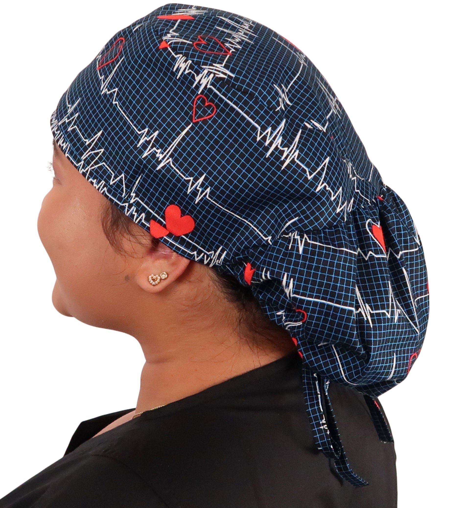 Side facing image untied of a woman in scrubs wearing a Big Hair Ponytail Scrub Cap with a Heartbeats on Navy pattern.