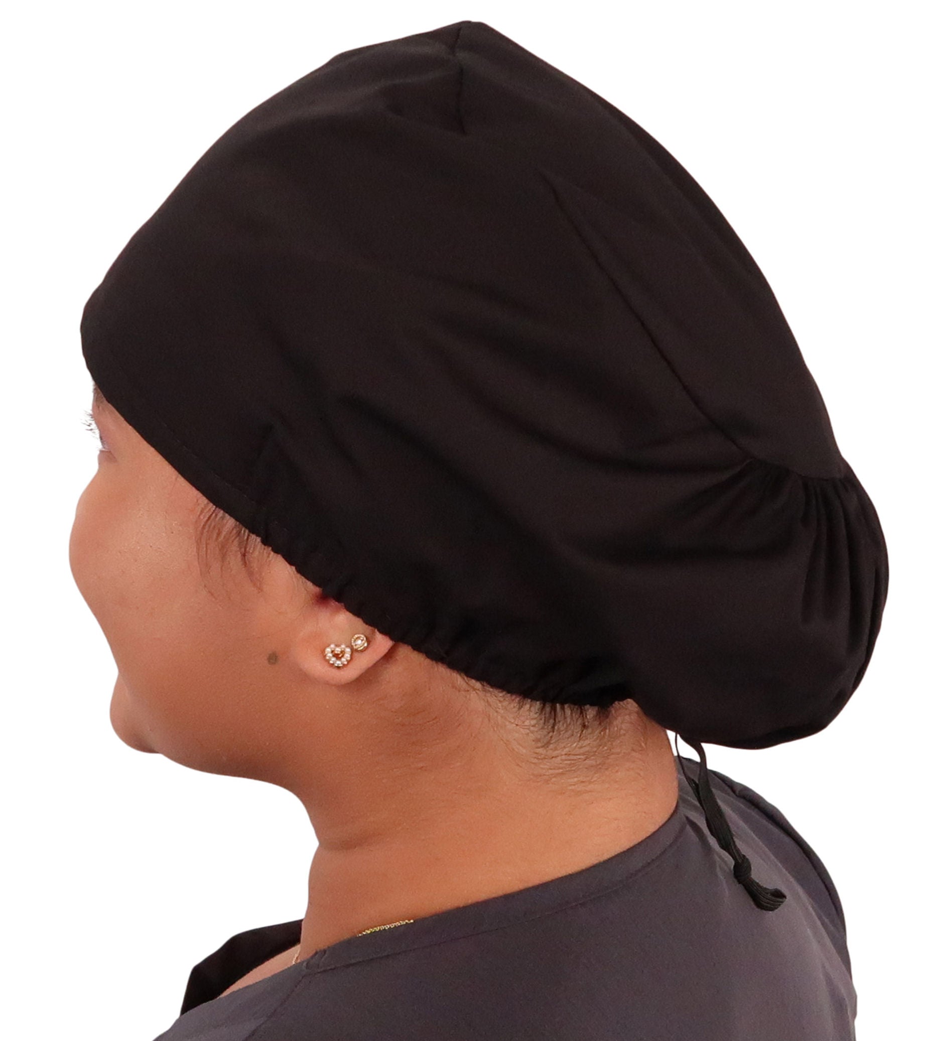 Side facing image of a woman in scrubs wearing a Black Euro Style Riley Comfort Scrub Cap.