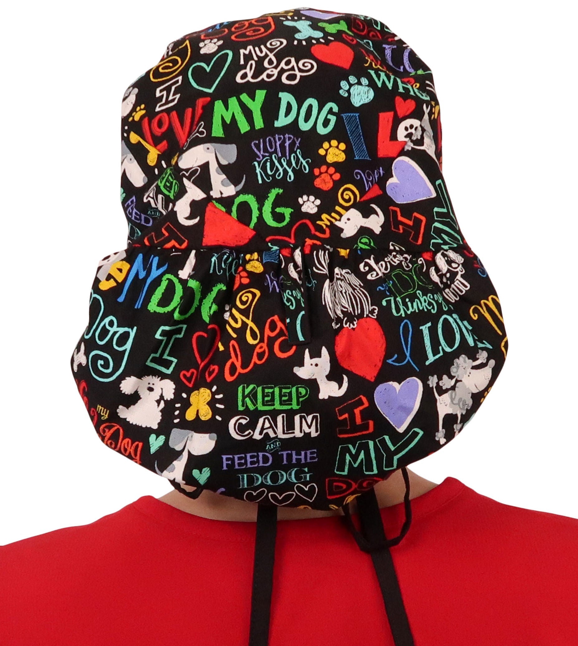 Back facing untied image of a woman in scrubs wearing a Big Hair Ponytail Scrub Cap with a I Love My Dog pattern, and black ties to hold the scrub cap in place