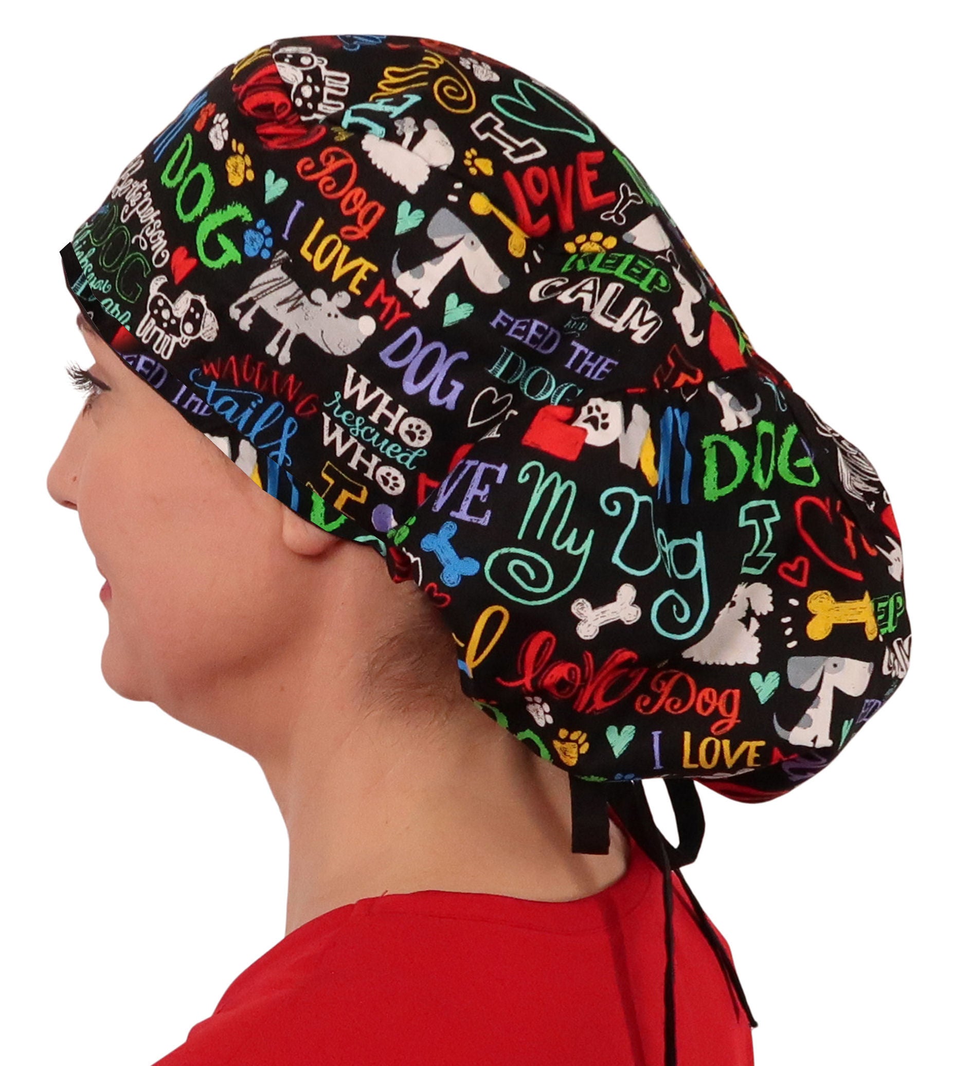 Side facing untied image of a woman in scrubs wearing a Big Hair Ponytail Scrub Cap with a I Love My Dog pattern, and black ties to hold the scrub cap in place