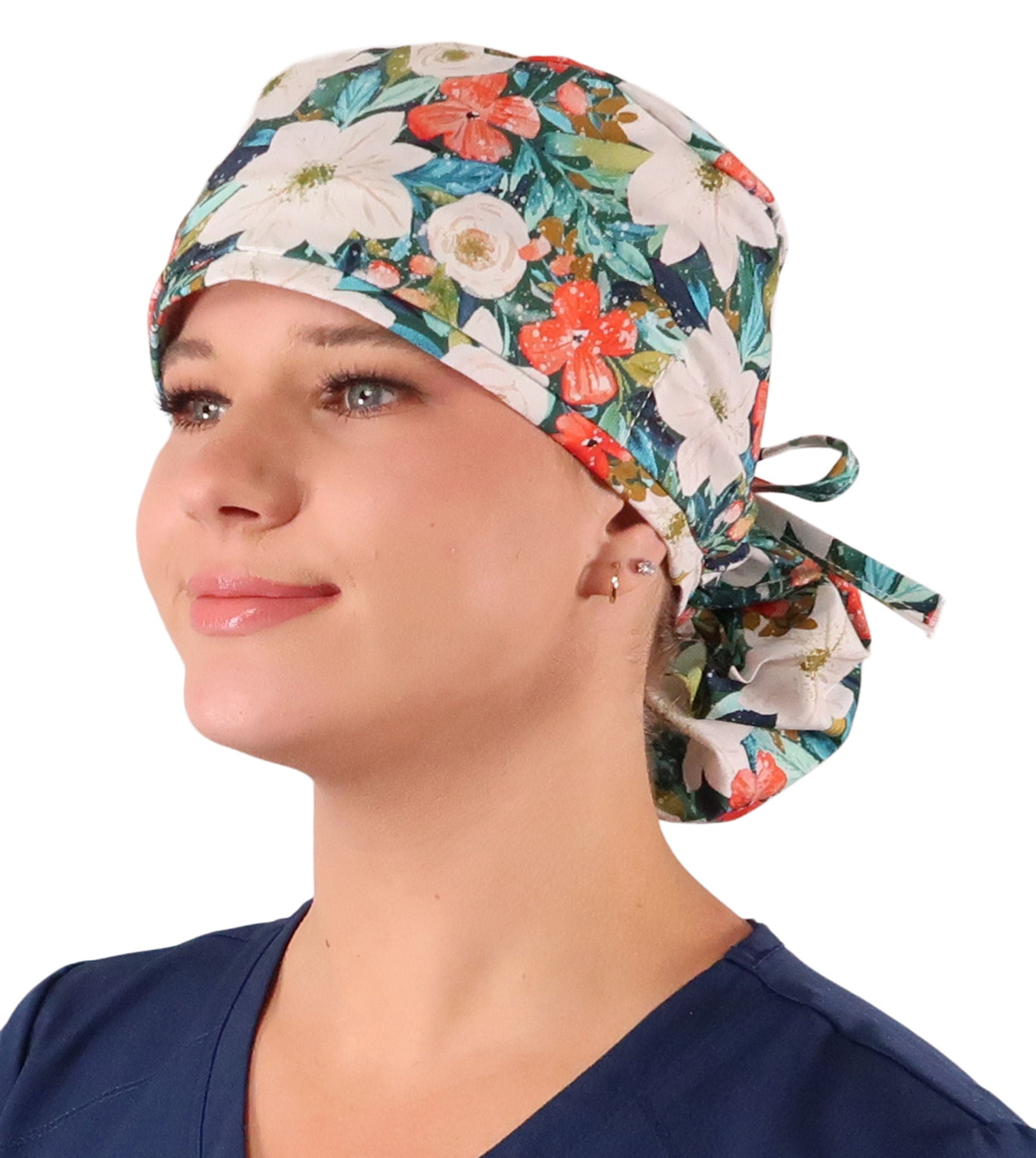 Front facing tied image of a woman in scrubs wearing a Big Hair Ponytail Scrub Cap with a Lush Winter Foliage pattern.