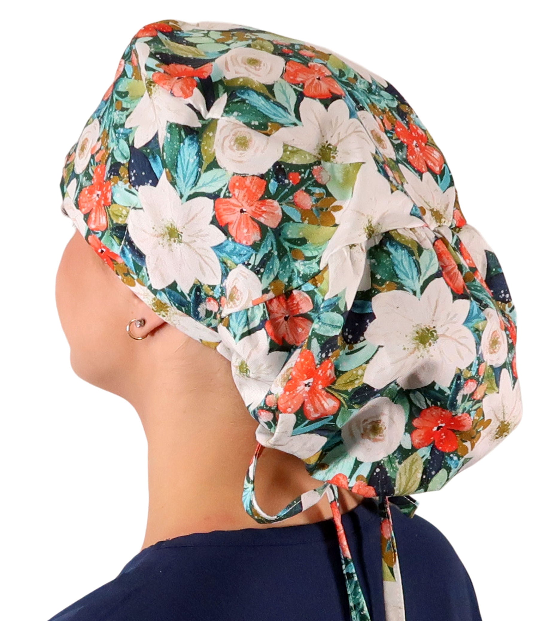 Side facing untied image of a woman in scrubs wearing a Big Hair Ponytail Scrub Cap with a Lush Winter Foliage pattern.
