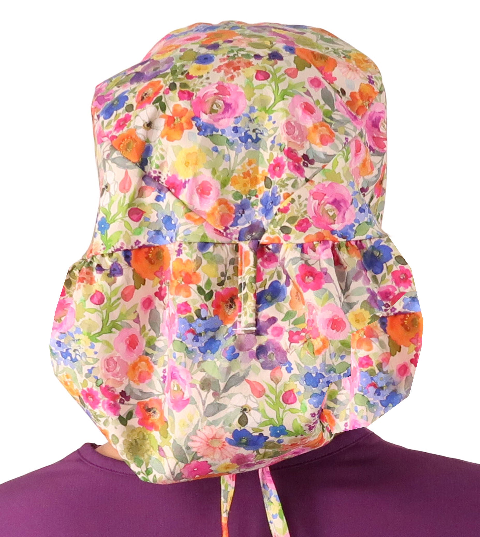 Back facing untied image of a woman in scrubs wearing a Big Hair Ponytail Scrub Cap with a Wondrous Wildflowers pattern.