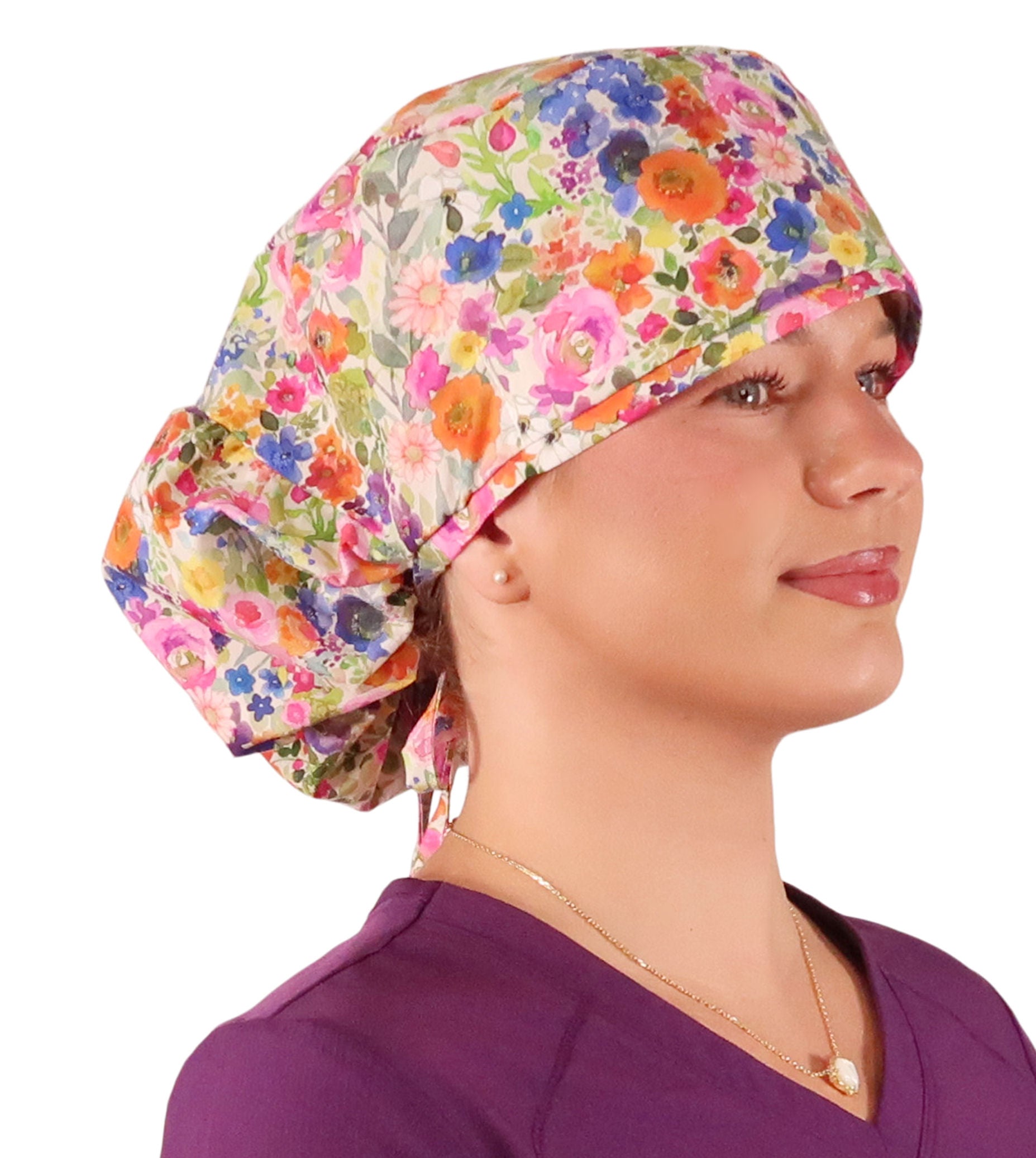Side facing untied image of a woman in scrubs wearing a Big Hair Ponytail Scrub Cap with a Wondrous Wildflowers pattern.