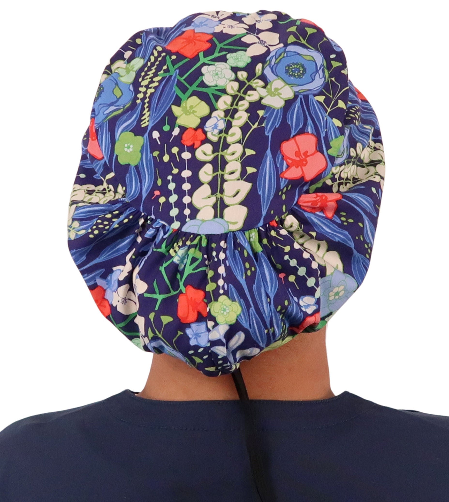 Back facing image of a woman in scrubs wearing a Flowing Blue Florals Euro Style Riley Comfort Scrub Cap.