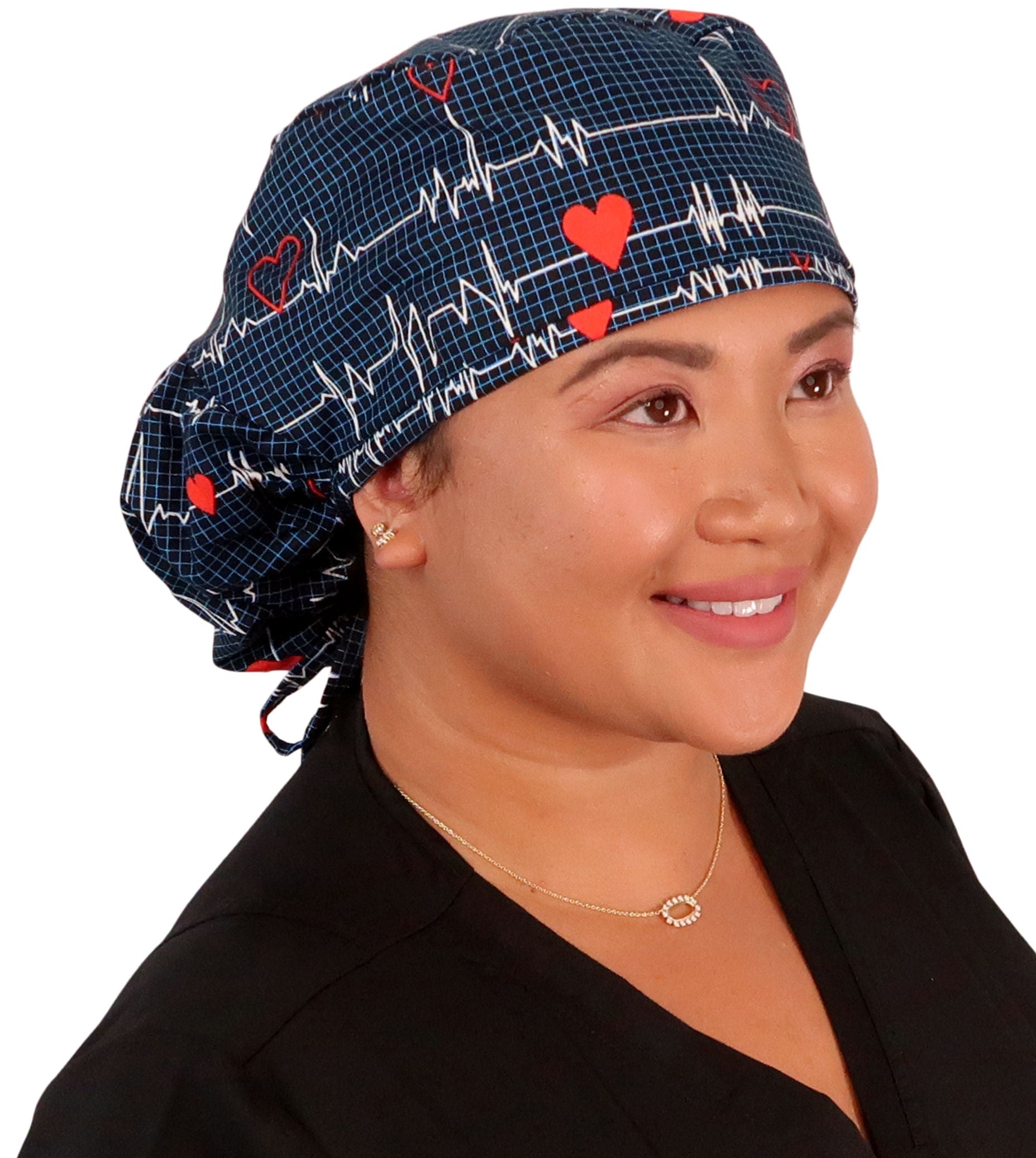 Front facing image untied of a woman in scrubs wearing a Big Hair Ponytail Scrub Cap with a Heartbeats on Navy pattern.