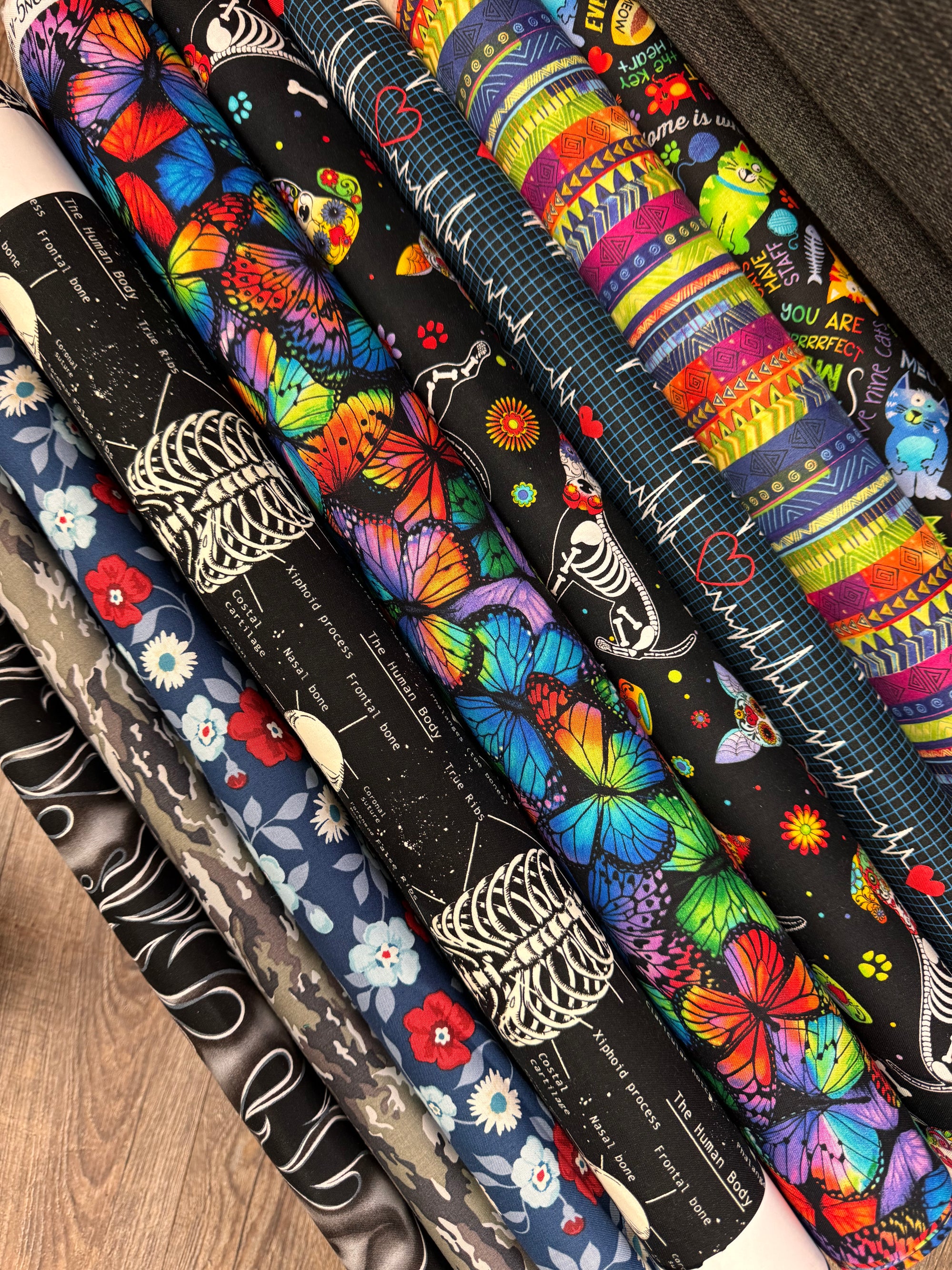 Collection of colorful fabric rolls with various patterns on a wooden surface