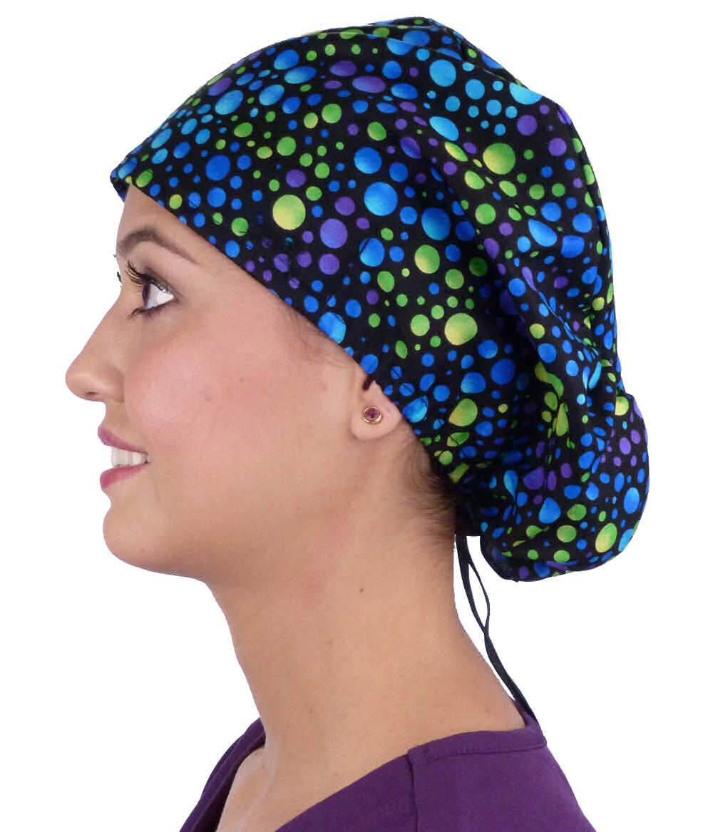 Side facing image of a woman in scrubs wearing a Blue, Green and Purple Dots Euro Style Riley Comfort Scrub Cap.