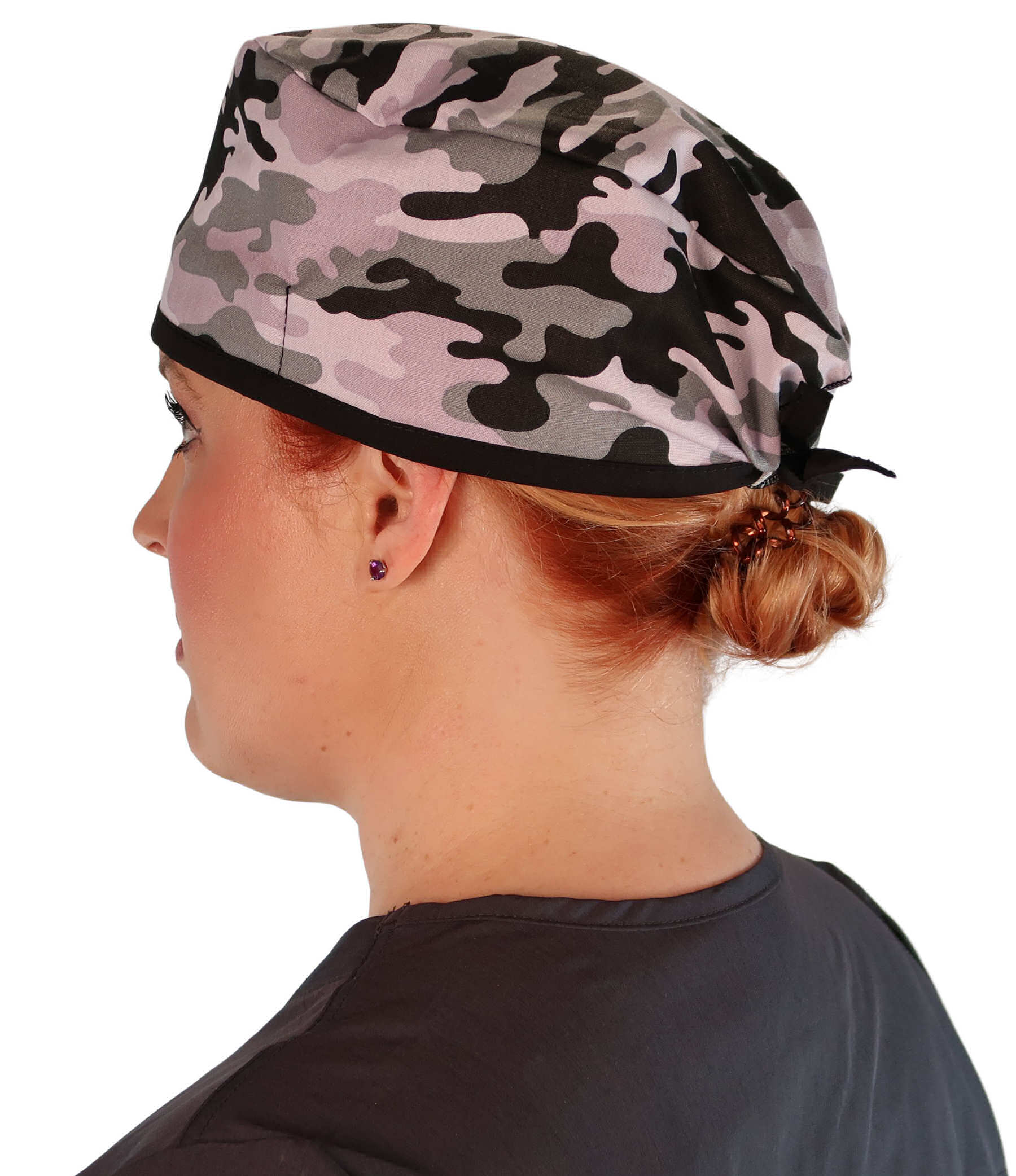 Side Facing View of a Woman Wearing a Classic Cotton Surgical Scrub Cap - Kickin Camo Black and Grey with Black Ties Pattern.