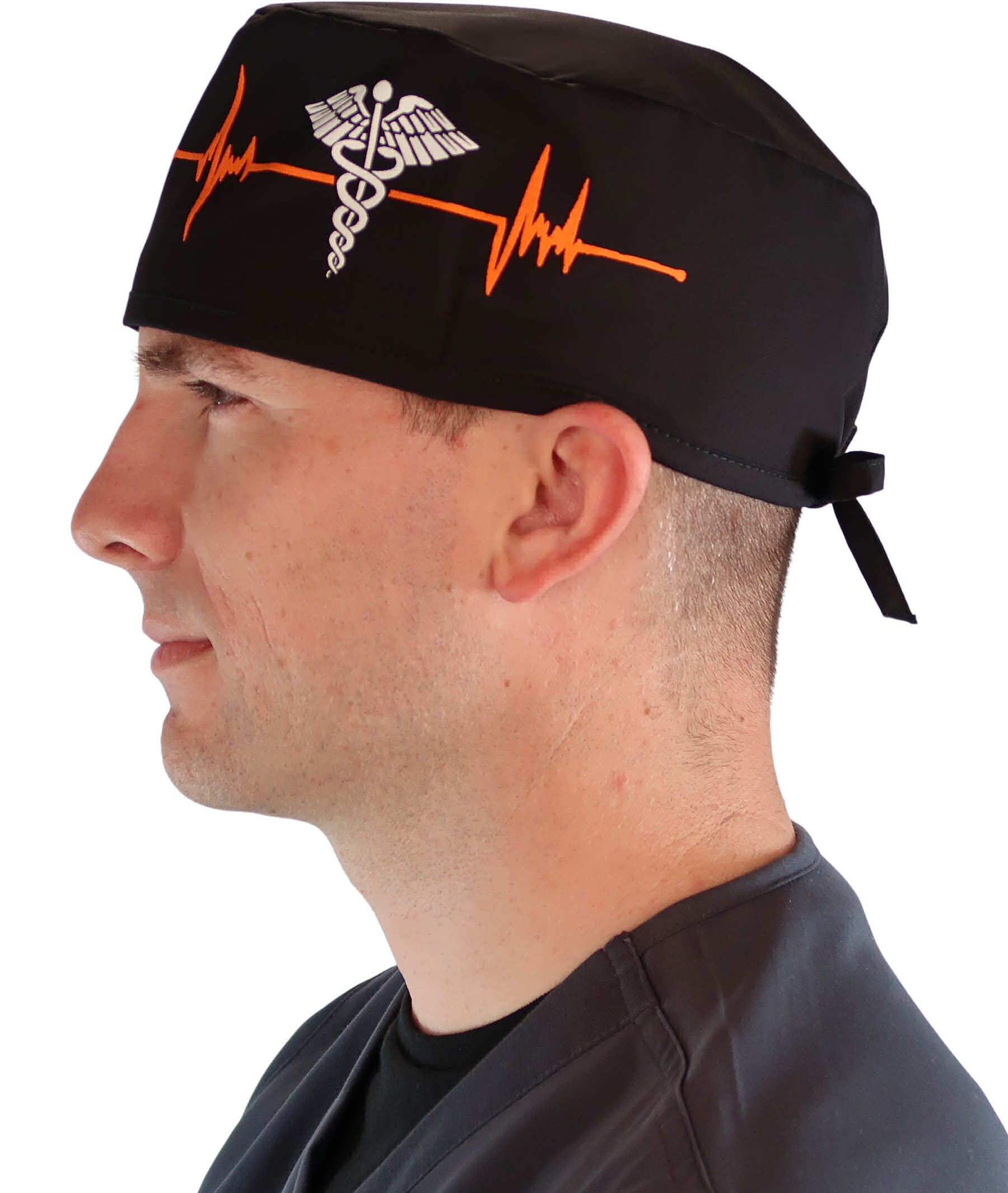 Side facing image of a man in scrubs wearing a Classic Surgical Scrub Cap in a EKG Signal and Medical Sign pattern.