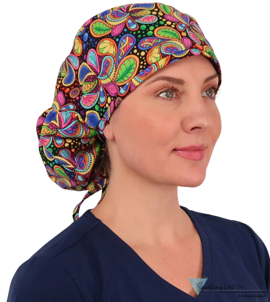 Front facing untied image of a woman in scrubs wearing a Big Hair Ponytail Scrub Cap with a Bright Flower Paisley pattern