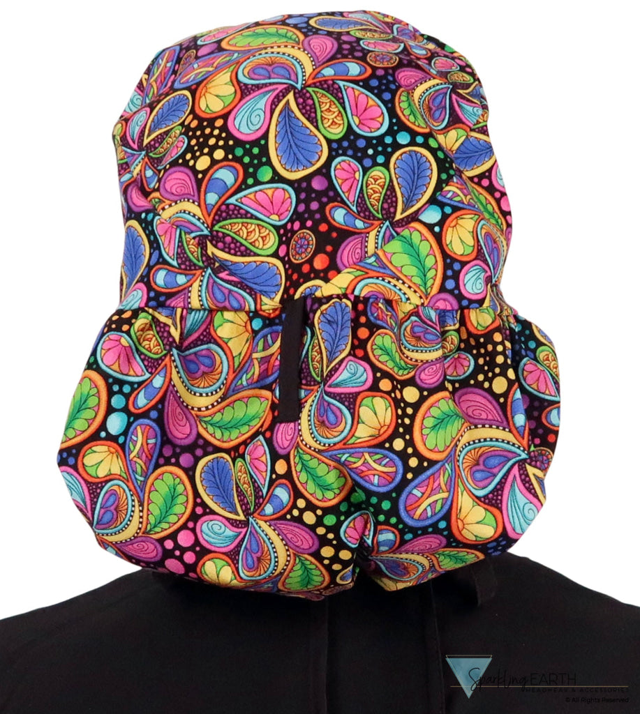 Back facing untied image of a woman in scrubs wearing a Big Hair Ponytail Scrub Cap with a Bright Flower Paisley pattern