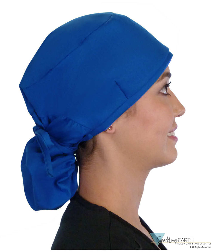 Side facing tied image of a woman in scrubs wearing a Royal Big Hair Ponytail Scrub Cap and royal ties to hold the scrub cap in place.