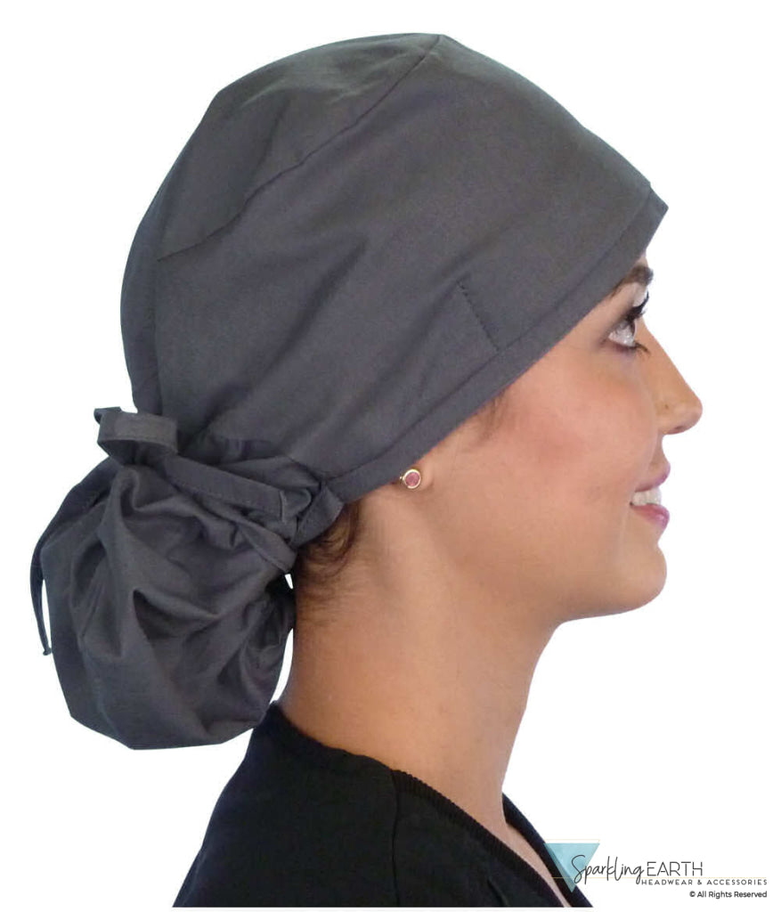 Side facing tied image of a woman in scrubs wearing a Grey Big Hair Ponytail Scrub Cap and grey ties to hold the scrub cap in place.