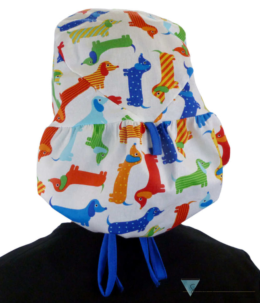 Back facing untied image of a woman in scrubs wearing a Big Hair Ponytail Scrub Cap with a Tossed Wiener Dogs pattern, and royal ties to hold the scrub cap in place.