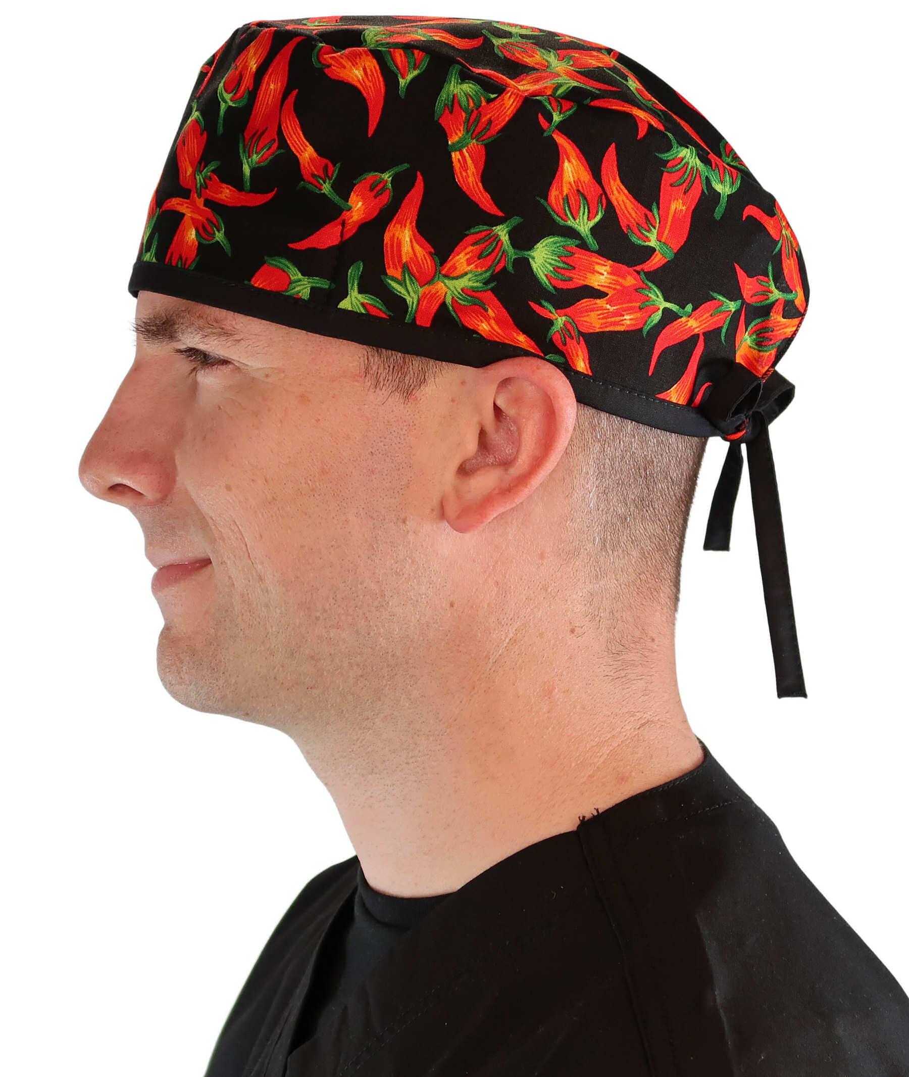 Side facing image of a man in scrubs wearing a Classic Surgical Scrub Cap in a Mixed Chili Peppers pattern.