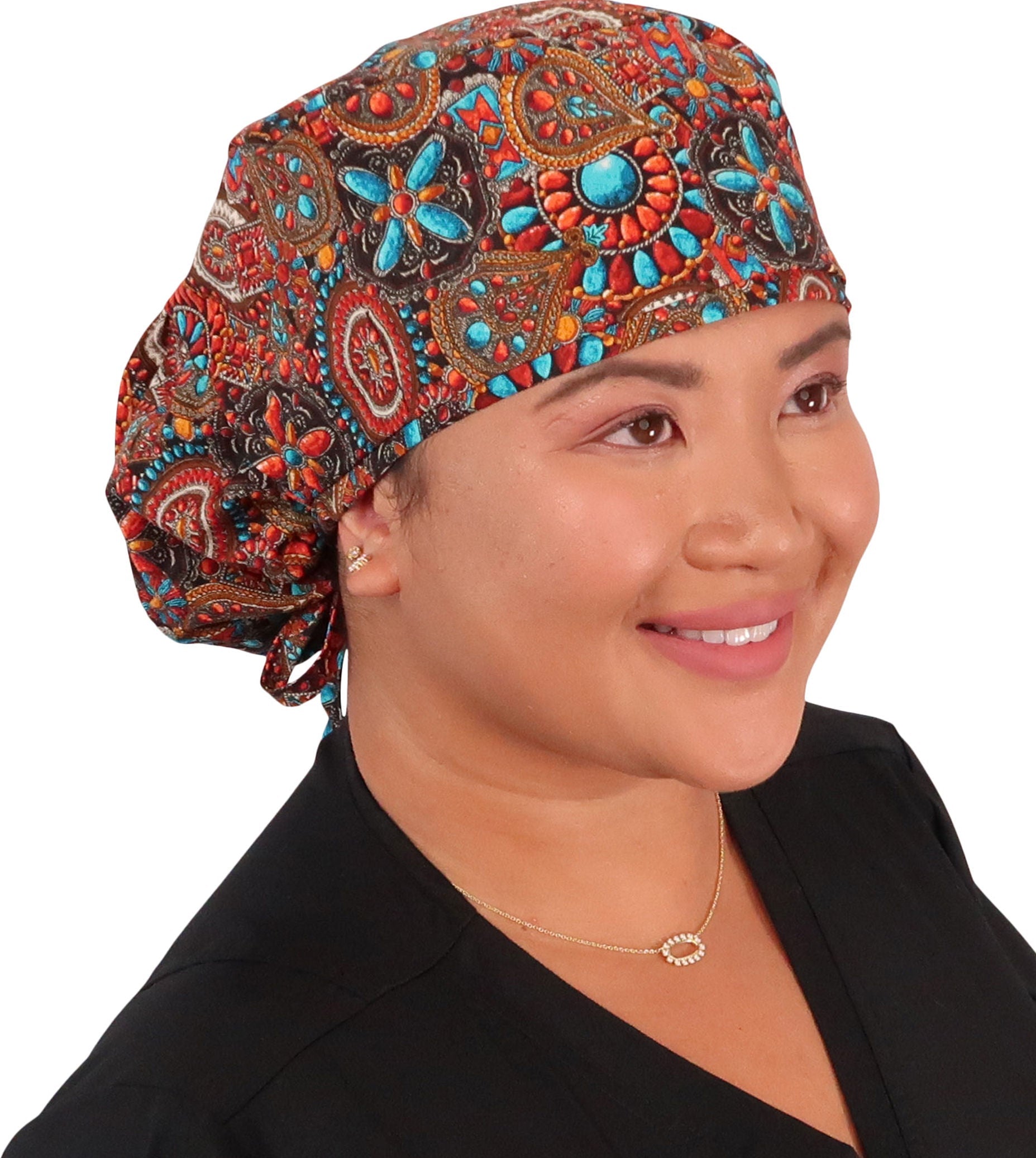 Front facing untied image of a woman in scrubs wearing a Indian Jewelry Big Hair Ponytail Scrub Cap and same fabric ties to hold the scrub cap in place.