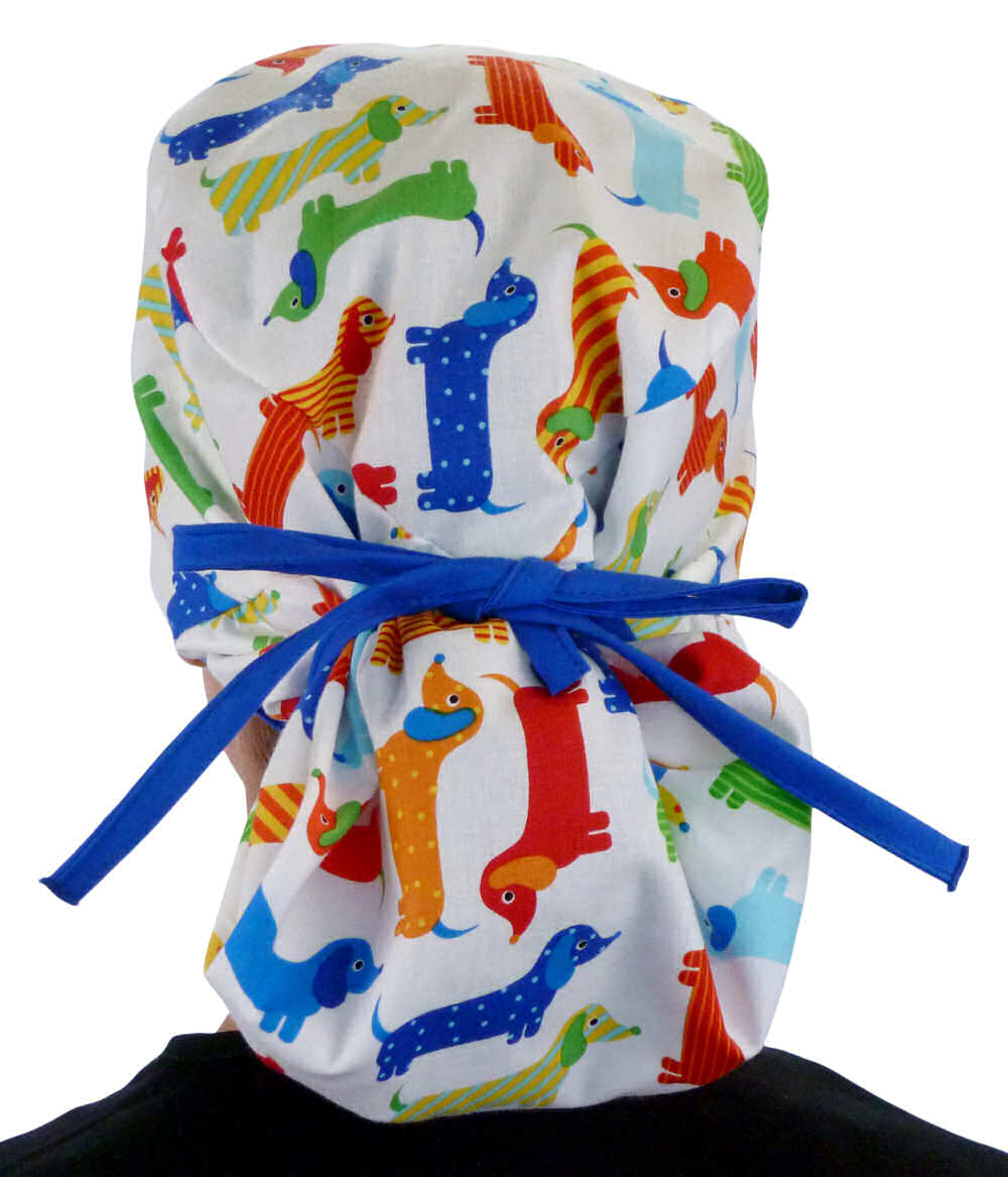 Back facing tied image of a woman in scrubs wearing a Big Hair Ponytail Scrub Cap with a Tossed Wiener Dogs pattern, and royal ties to hold the scrub cap in place.