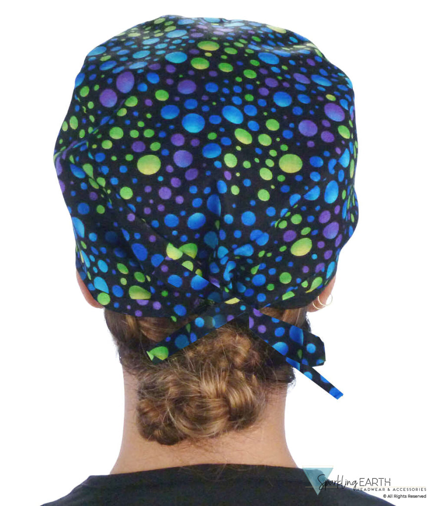 Back facing image of a woman in scrubs wearing a Classic Surgical Scrub Cap in a Blue, Green and Purple Dots pattern.