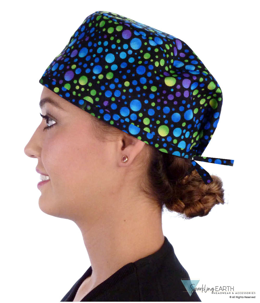 Side facing image of a woman in scrubs wearing a Classic Surgical Scrub Cap in a Blue, Green and Purple Dots pattern.
