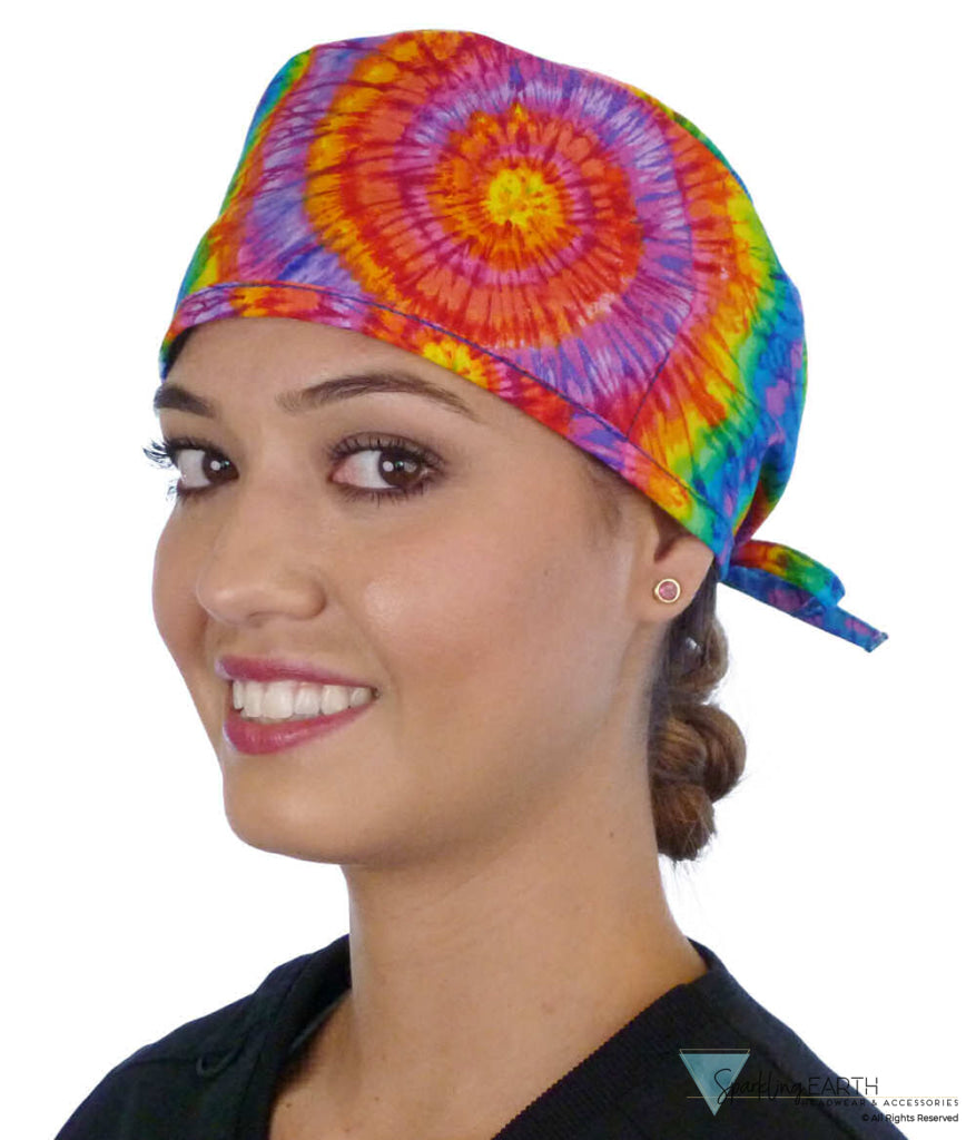 Front facing image of a woman in scrubs wearing a Classic Surgical Scrub Cap in a Tie Dye pattern.
