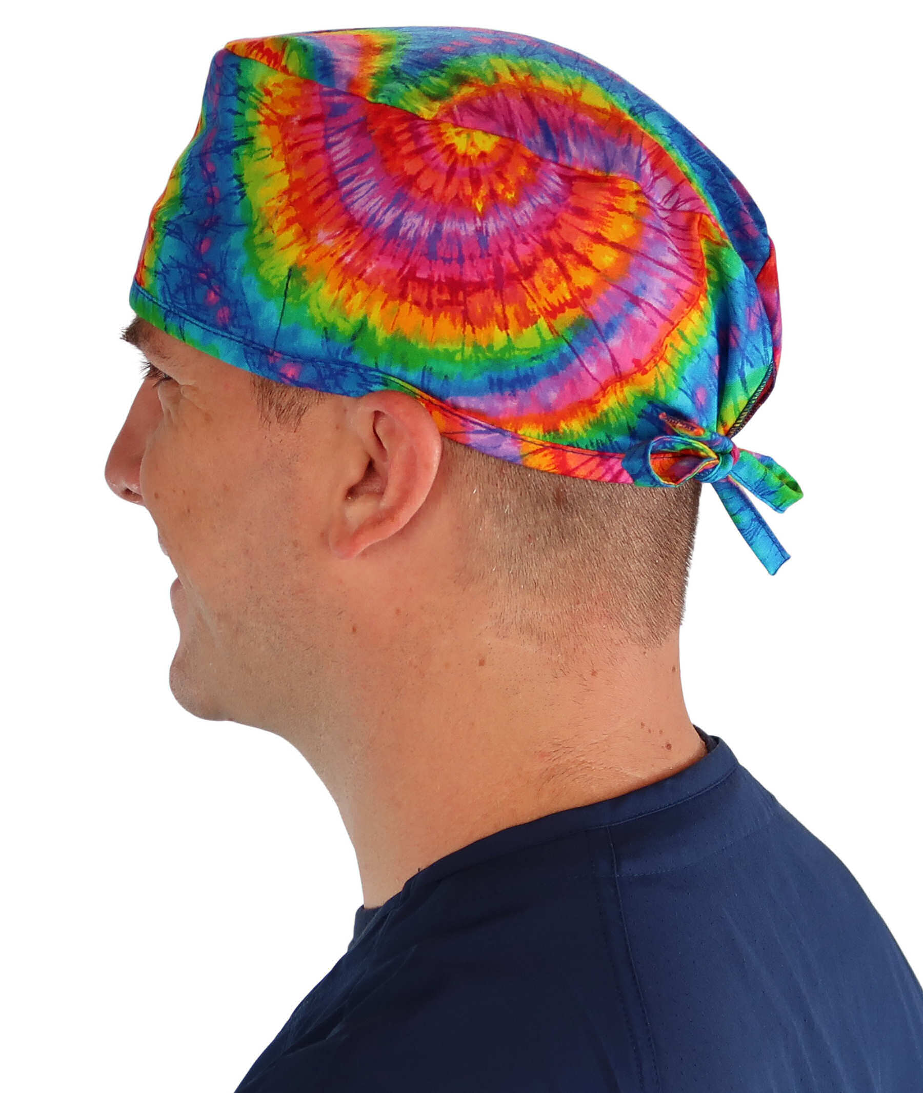 Side facing image of a man in scrubs wearing a Classic Surgical Scrub Cap in a Tie Dye pattern.