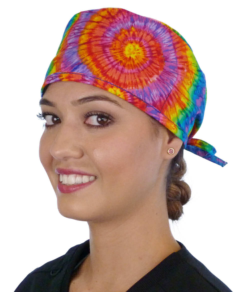 Front facing image of a woman in scrubs wearing a Classic Surgical Scrub Cap in a Tie Dye pattern.