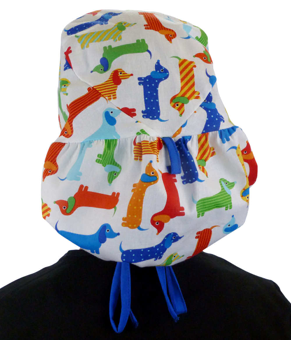 Back facing untied image of a woman in scrubs wearing a Big Hair Ponytail Scrub Cap with a Tossed Wiener Dogs pattern, and royal ties to hold the scrub cap in place.