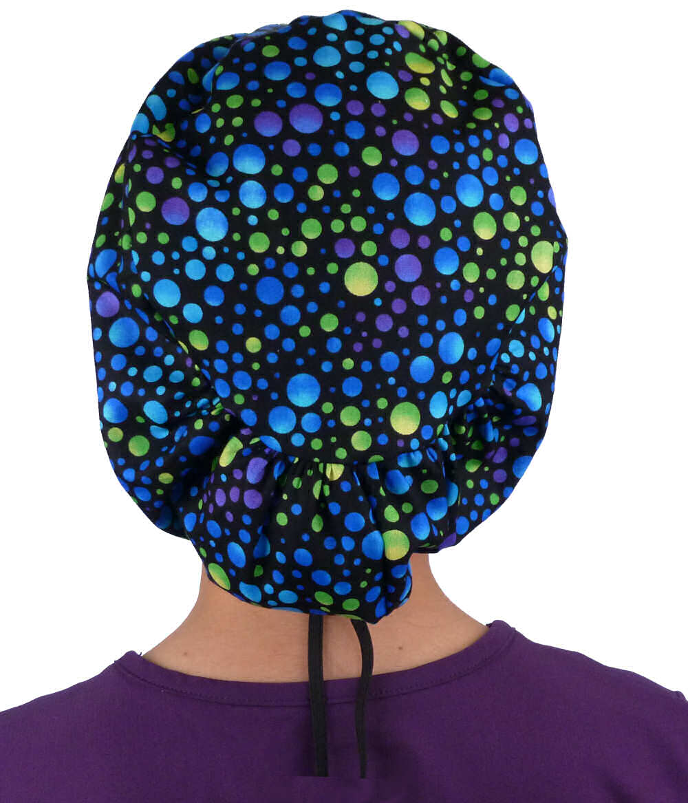 Back facing image of a woman in scrubs wearing a Blue, Green and Purple Dots Euro Style Riley Comfort Scrub Cap.