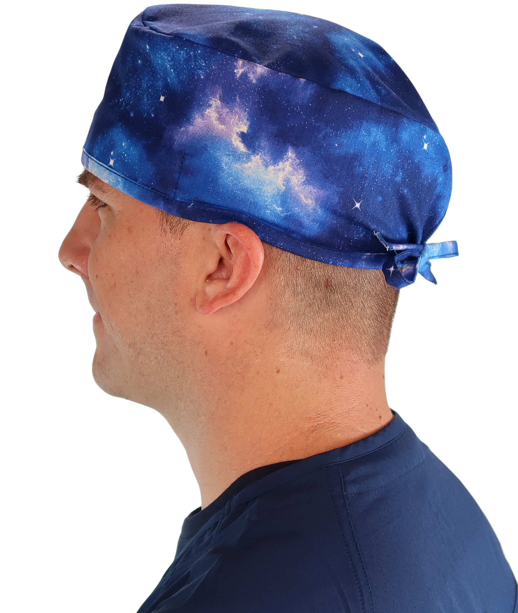 Side facing image of a man in scrubs wearing a Classic Surgical Scrub Cap with a Starry Sky pattern.